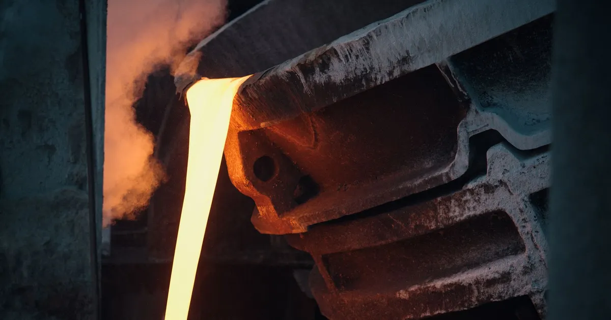 Stream of molten metal pouring into a mould in a foundry, an example of the casting process behind a cast steel weldment hybrid design